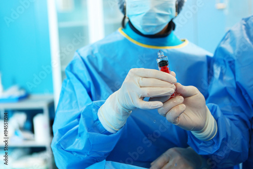 Fotografie Surgeons' hands in close-up with a syringe