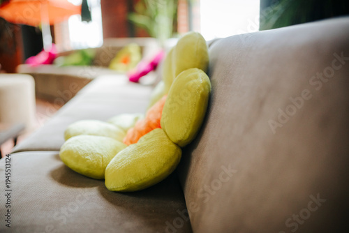 Obraz na plátně Colorful yellow green puffy cushions on sofa close-up, vibrant interior decorati