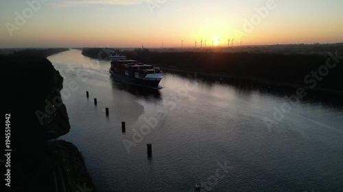 Containerschiff NORDICA fährt bei Sonnenaufgang im Nord-Ostsee-Kanal 