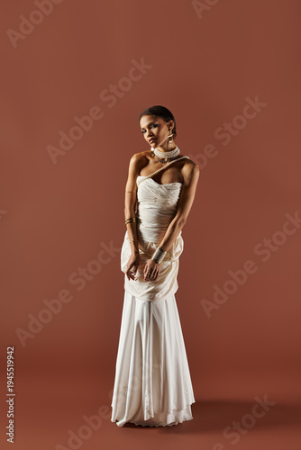 Charming young african american bride in a stunning white dress poses gracefully in studio