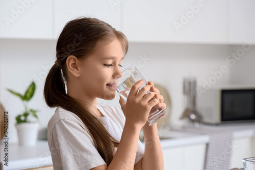 Adorable little girl drinki...