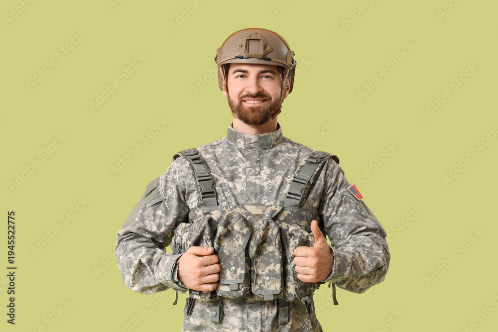 Obraz premium Young happy male soldier in uniform on green background