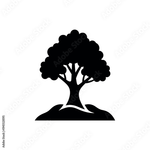 Black silhouette of a tree on a small hill.