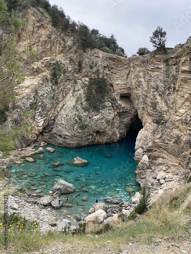 Fotografía Rocky cliff framing turquoise cove with clear shallow water