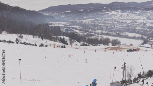 Drone following two skiers racing parallel slalom on snowy mountain competition slope