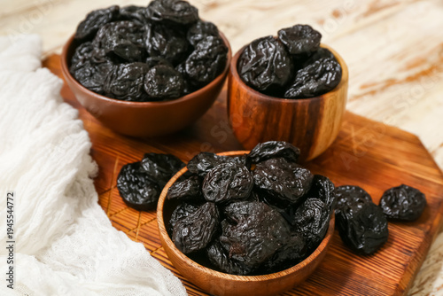 Bowls with dried prunes on ...