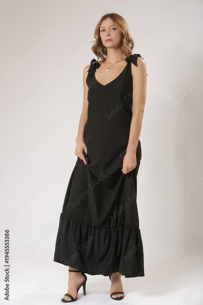 Fototapeta premium Fashion Model in Black Sleeveless Maxi Dress With V-Neck – Stylish Summer Fashion and Elegant Studio Concept