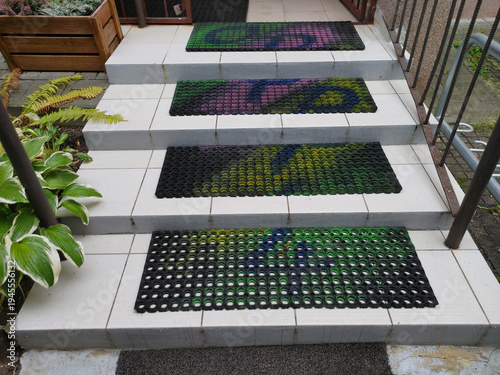 Outdoor concrete stairs decorated with colorful non-slip rubber mats leading up