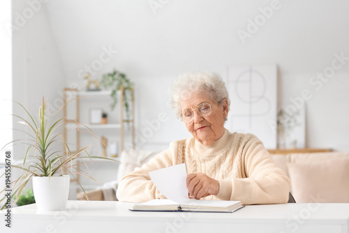 Senior woman reading Bible ...
