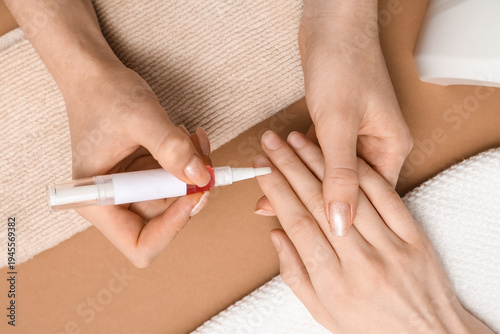 Manicure master applying cu...
