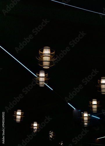 Warm lanterns glow against the dark night sky with streaks of blue light.