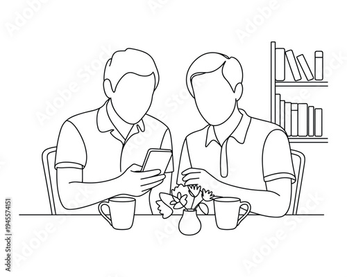 Two men looking at a mobile phone together while sitting at a table with coffee cups and a vase of flowers
