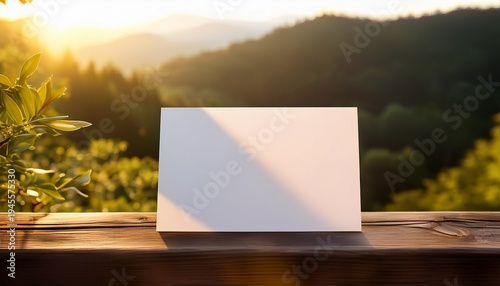 Blank White Paper Card Mockup On A Rustic Wooden Railing Illuminated By Warm Morning Sunlight In A Natural Outdoor Setting Perfect For Custom Messages Or Elegant Design Presentations