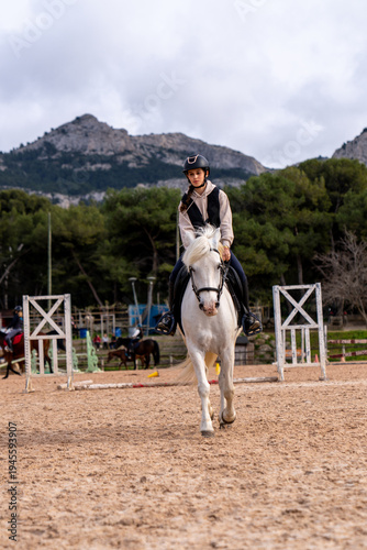 Horse riding - portrait of lovely equestrian on a white horse