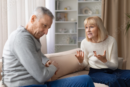 Foto Senior couple experiencing relationship conflict while talking on sofa at home