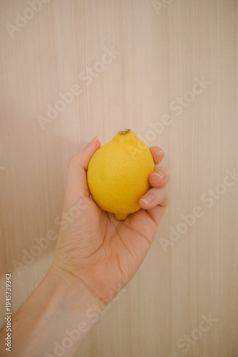 A hand holding a lemon