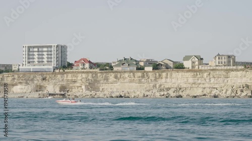 Large sturgeon swimming in a circular concrete aquaculture tank at an indoor fish farm facility.