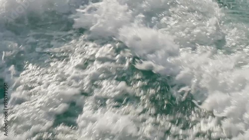 Close up view of white sea foam and splashing ocean water waves in motion.