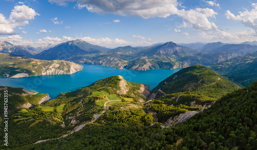 Aerial view of turquoise water of Lake Serre-Poncon in the French Alps. Summer in mountains and forests of Hautes-Alpes, France