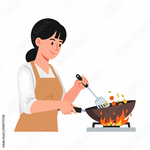 A smiling woman in an apron stir-frying vegetables in a wok over a gas stove with flames.