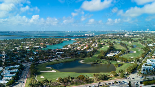 Drone view of green golf fairways and waterfront neighborhood Miami Beach