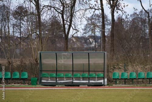 Canvas Print Green plastic seats on a substitute bench at a local sports stadium