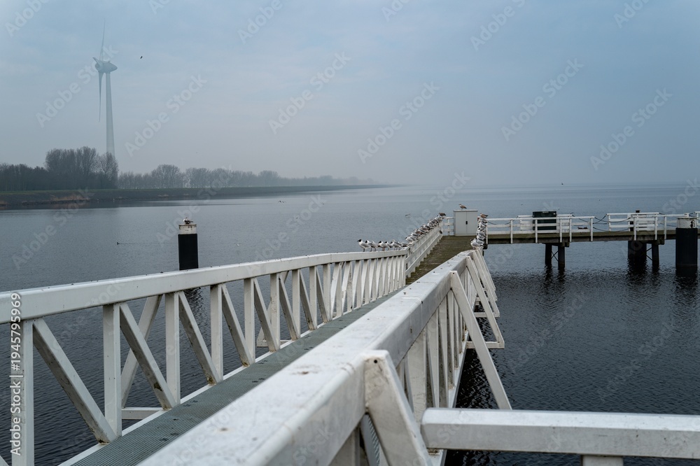 Obraz premium White pier with seagulls and wind turbine in medemblik