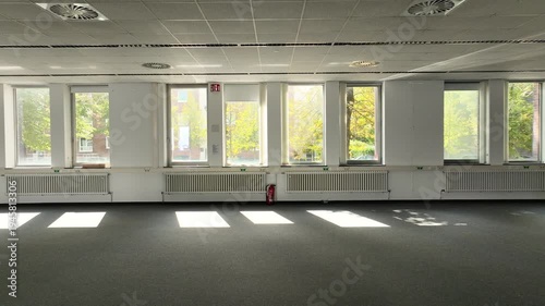 Spacious, vacant office with glass partitions, ideal for commercial real estate, architecture, and business concepts. 
