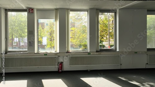 Spacious, vacant office with glass partitions, ideal for commercial real estate, architecture, and business concepts. 
