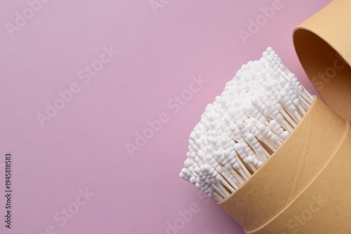 Slika na platnu Cardboard box with cotton swabs on purple background