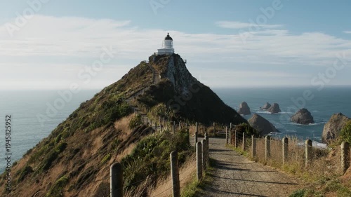 Nugget Point Lighthouse on rocky headland with sea stacks and ocean, Catlins, New Zealand