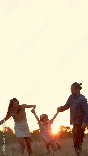 Family with son walking on field on wind farm. Happy Family and son playing at the Wind turbines generating electricity. Family time together.
