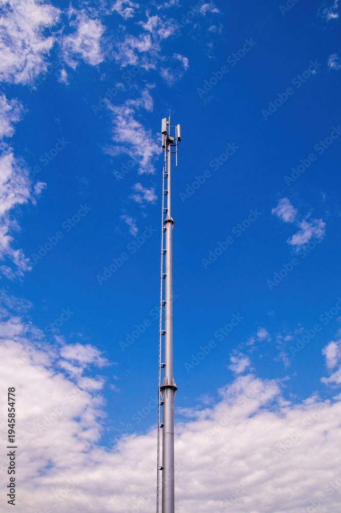 Obraz premium Modern telecommunications tower reaching into a blue sky