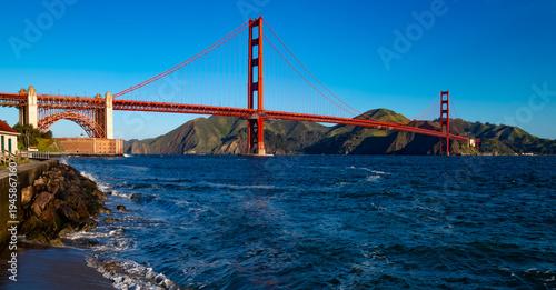 Canvas Print Wide-angle panorama of the world-famous red Golden Gate Bridge on a windy, sunny spring morning, viewed from Torpedo Wharf on the south side