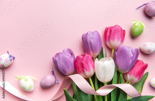 Colorful easter tulips and decorative eggs on pink background