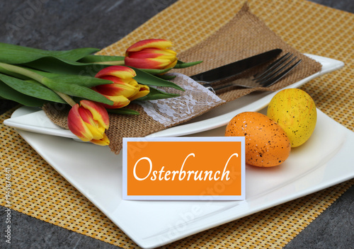 Gedeckter Ostertisch mit Osterdekoration und einer Tischkarte mit der Beschriftung Osterbrunch.	