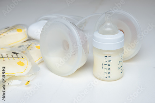Breast pump, baby bottle, and breast milk storage bags on a light background. 