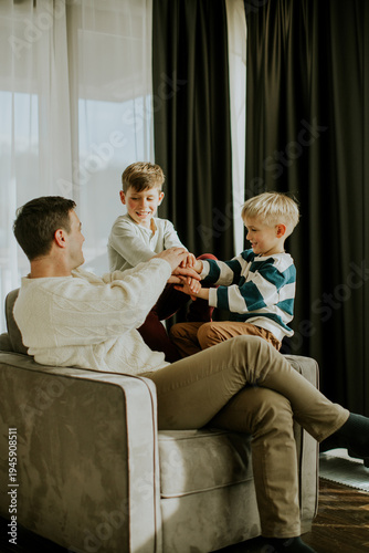 Father plays with two sons ...