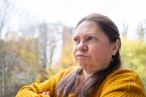 Furious woman staring aggressively, Middle-aged woman making disgusted face outdoors, Facial expression of discomfort, surprise, or awkward social situation, negative social situation
