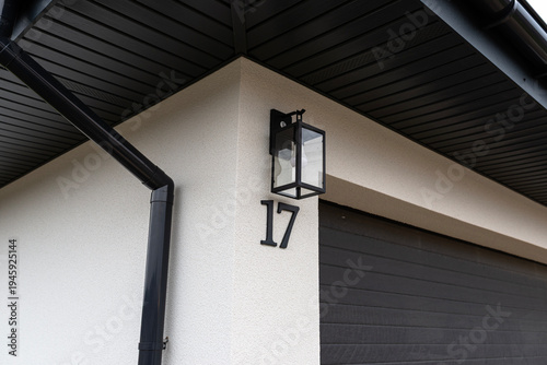 House number 17 on modern building exterior with lamp