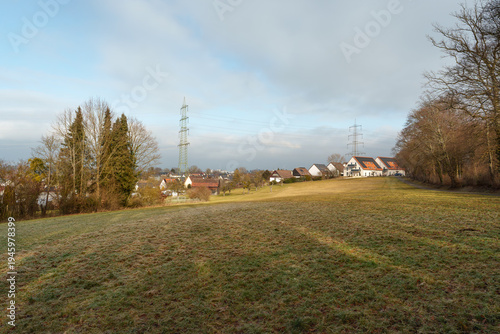 Rural landscape with houses, solar panels, and high voltage power lines near Nurtingen