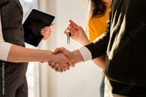 Foto Close up of real estate agent handshake with her clients because of new apartment