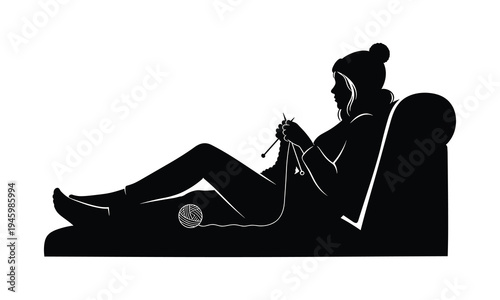 A relaxed individual knitting while reclining on a comfortable armchair