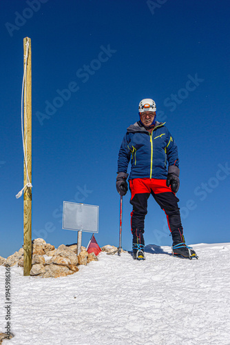The alpinist is enjoying the coffee at the summit of Kızlarsivrisi mountain (3070 m.) in Antalya, Turkey