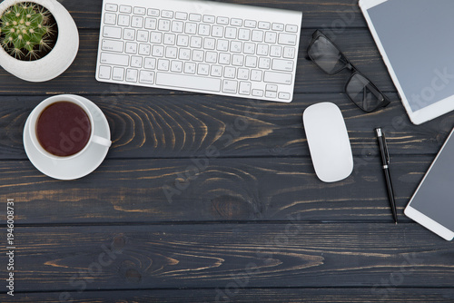 Modern workplace with smartphone and keyboard copy space on wood background. Top view. coffee cup.