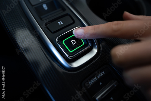Fotografia close-up shot of hand pressing the illuminated drive (D) button on a modern car