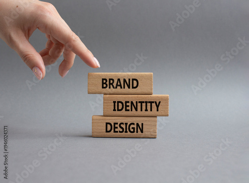 Brand identity design symbol. Concept word Brand identity design on wooden blocks. Businessman hand. Beautiful grey background. Business and Brand identity design. Copy space
