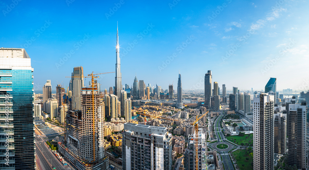 Obraz premium Panoramic skyline of Dubai with modern skyscrapers and futuristic architecture at sunset. Iconic cityscape of the largest city in the United Arab Emirates, famous for luxury tourism, business district