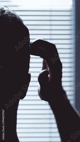 Head silhouette scratching with hand window blinds in background