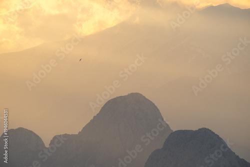 Принти на полотні Dramatic sun rays breaking through clouds over the Bey Mountains and the Mediterranean Sea during sunset near Antalya, Türkiye
